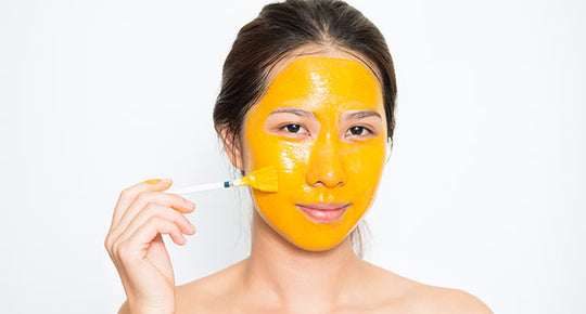 woman applying turmeric on face