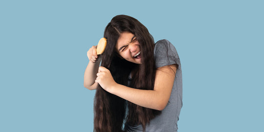 girl trying to detangle hair